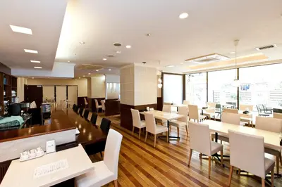 a dining room with tables and chairs and windows at Sotetsu Fresa Inn Tokyo Tamachi in Tokyo