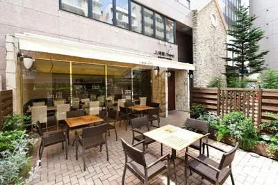 a patio with tables and chairs in front of a building at Sotetsu Fresa Inn Tokyo Tamachi in Tokyo
