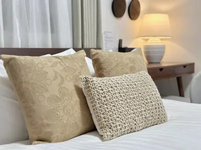 a bed with two pillows and a table with a lamp at LANG Hotel GINZA 1K in Tokyo