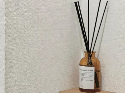 a vase with sticks in it sitting on a table at LANG Hotel GINZA 1K in Tokyo