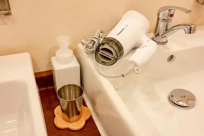 a bathroom with a blow dryer on the sink at plat hostel keikyu asakusa karin in Tokyo