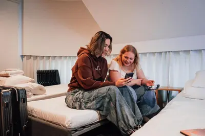two people sitting on a bed looking at their cell phones at UNPLAN Shinjuku in Tokyo