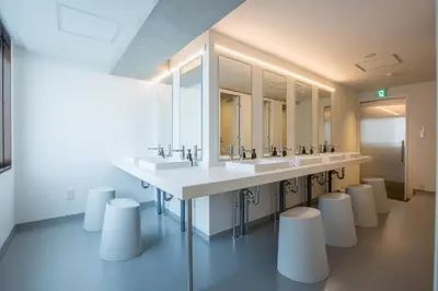 a bathroom with a row of sinks and mirrors at UNPLAN Shinjuku in Tokyo