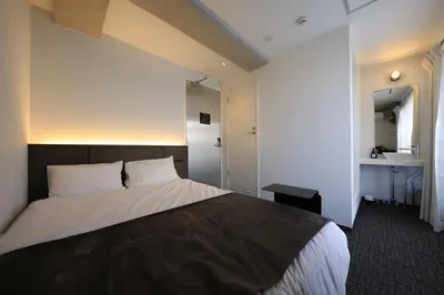 a bedroom with a large bed and a sink at UNPLAN Shinjuku in Tokyo