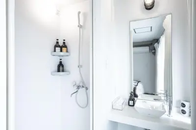 a white bathroom with a sink and a mirror at UNPLAN Shinjuku in Tokyo