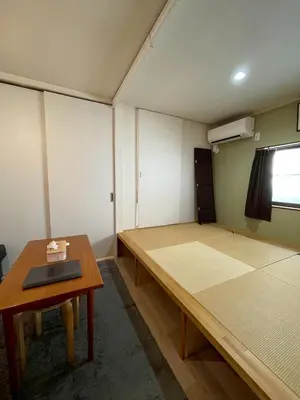 a room with a bed and a table in it at Den 7 in Tokyo