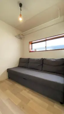 a large couch in a room with a window at Den 7 in Tokyo