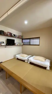 a bedroom with two beds and a wooden table at Den 7 in Tokyo