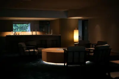a dark room with a table and chairs and a bar at DDD HOTEL in Tokyo