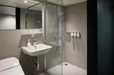 a bathroom with a shower and a sink and a toilet at DDD HOTEL in Tokyo