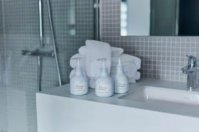 a bathroom with three bottles of soap on a sink at DDD HOTEL in Tokyo