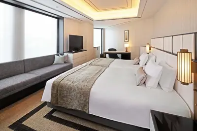 a bedroom with a large white bed and a couch at KOKO HOTEL Premier Nihonbashi Hamacho in Tokyo