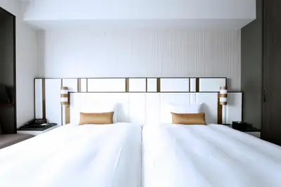 a bedroom with two white beds with two pillows at KOKO HOTEL Premier Nihonbashi Hamacho in Tokyo