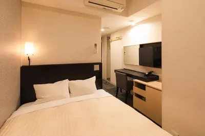 a hotel room with a bed and a desk at Sotetsu Fresa Inn Shimbashi Hibiyaguchi in Tokyo