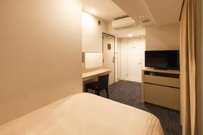 a hotel room with a bed and a desk at Sotetsu Fresa Inn Shimbashi Hibiyaguchi in Tokyo