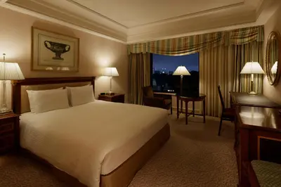 a hotel room with a large bed and a desk and a desk at Rihga Royal Hotel Tokyo in Tokyo