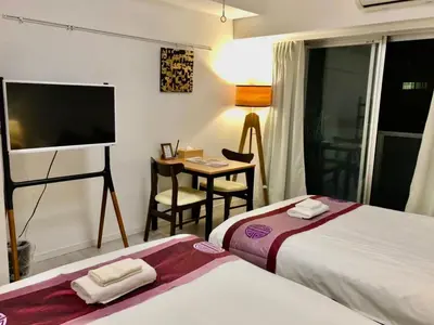 a hotel room with two beds and a flat screen tv at \u30ea\u30d6\u30b7\u30c6\u30a3\u9326\u7cf8\u753a\u53c2\u756a\u9928\u4e0a\u5c64\u968e\u30b9\u30ab\u30a4\u30c4\u30ea\u30fc\u306e\u773a\u671b, Akihabara 6mins,Tokyo 8 mins, Direct to Narita Airport \u6210\u7530\u7a7a\u6e2f\u76f4\u9054 in Tokyo