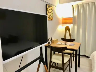a small room with a table and chairs and a bed at \u30ea\u30d6\u30b7\u30c6\u30a3\u9326\u7cf8\u753a\u53c2\u756a\u9928\u4e0a\u5c64\u968e\u30b9\u30ab\u30a4\u30c4\u30ea\u30fc\u306e\u773a\u671b, Akihabara 6mins,Tokyo 8 mins, Direct to Narita Airport \u6210\u7530\u7a7a\u6e2f\u76f4\u9054 in Tokyo