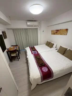 a bedroom with a large bed and a table at \u30ea\u30d6\u30b7\u30c6\u30a3\u9326\u7cf8\u753a\u53c2\u756a\u9928\u4e0a\u5c64\u968e\u30b9\u30ab\u30a4\u30c4\u30ea\u30fc\u306e\u773a\u671b, Akihabara 6 mins, Tokyo Station 8 mins, Direct to Narita Airport \u6210\u7530\u7a7a\u6e2f\u76f4\u9054 in Tokyo