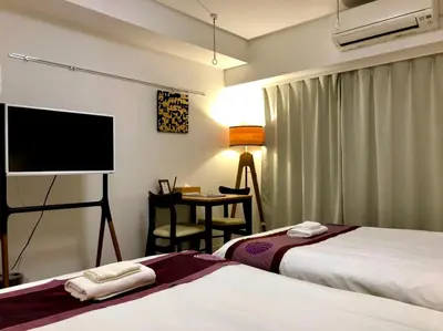 a hotel room with two beds and a flat screen tv at \u30ea\u30d6\u30b7\u30c6\u30a3\u9326\u7cf8\u753a\u53c2\u756a\u9928\u4e0a\u5c64\u968e\u30b9\u30ab\u30a4\u30c4\u30ea\u30fc\u306e\u773a\u671b, Akihabara 6 mins, Tokyo Station 8 mins, Direct to Narita Airport \u6210\u7530\u7a7a\u6e2f\u76f4\u9054 in Tokyo