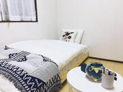 a room with two beds and a table with a bowl on it at Alo BnB 3 - Near KOMAGOME, IKEBUKURO, SHINJUKU, UENO - MAX 16 PAX in Tokyo