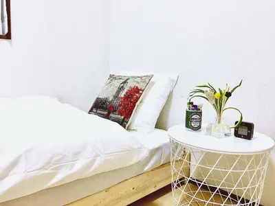 a bedroom with a bed and a table with a vase on it at Alo BnB 3 - Near KOMAGOME, IKEBUKURO, SHINJUKU, UENO - MAX 16 PAX in Tokyo
