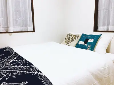 two beds in a room with white walls at Alo BnB 3 - Near KOMAGOME, IKEBUKURO, SHINJUKU, UENO - MAX 16 PAX in Tokyo