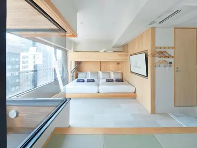 a bedroom with a bed and a large window at Sakura Cross Hotel Akihabara in Tokyo