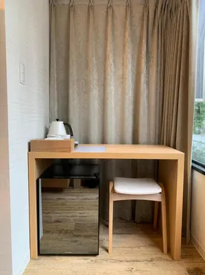 a wooden desk with a chair next to a curtain at Sakura Cross Hotel Akihabara in Tokyo