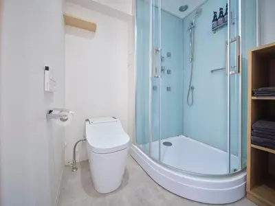 a bathroom with a toilet and a glass shower at Sakura Cross Hotel Akihabara in Tokyo