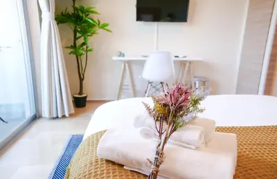 a room with a bed with towels and a flower on it at Dash Living Tsukiji in Tokyo