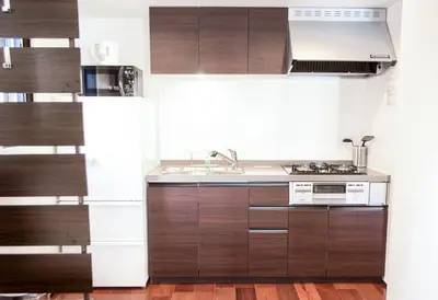 a kitchen with wooden cabinets and a sink at Dash Living Tsukiji in Tokyo