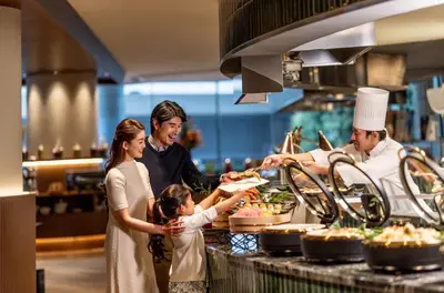 a group of people standing in a kitchen preparing food at ANA InterContinental Tokyo by IHG in Tokyo