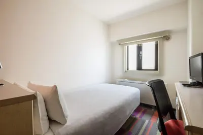 a hotel room with a bed and a television at the b sangenjaya in Tokyo