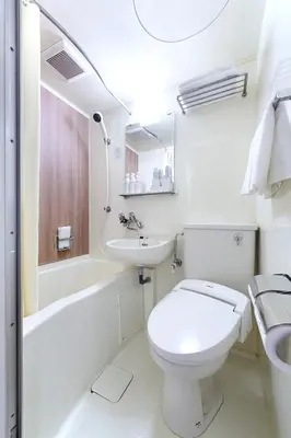 a white bathroom with a toilet and a sink at the b sangenjaya in Tokyo