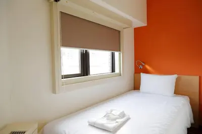 a bedroom with a bed with a white towel on it at the b sangenjaya in Tokyo