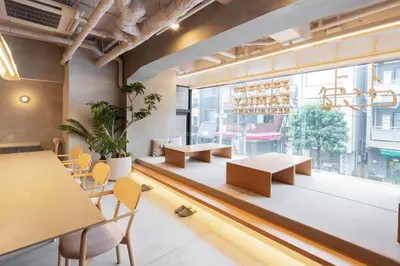 a restaurant with tables and chairs and a large window at the b sangenjaya in Tokyo