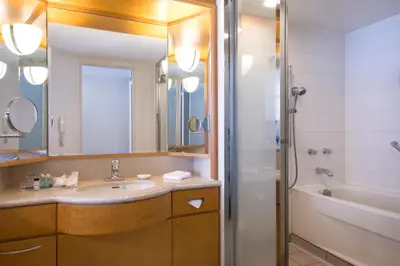 a bathroom with a sink and a mirror and a tub at Sheraton Grande Tokyo Bay Hotel in Urayasu