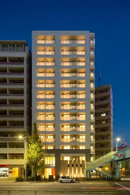 a tall building with lights on in a parking lot at Oakwood Apartments Minami Azabu Tokyo in Tokyo