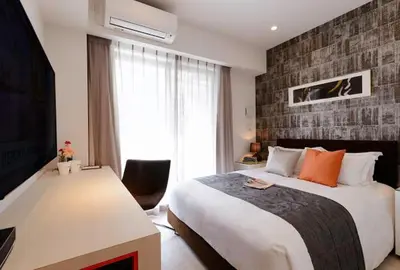 a bedroom with a large bed and a television at Oakwood Apartments Minami Azabu Tokyo in Tokyo