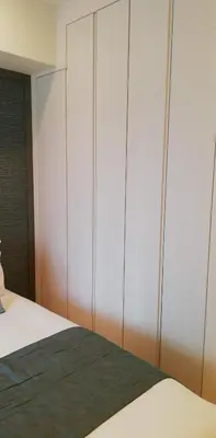 a bedroom with a bed with white cabinets at Oakwood Apartments Minami Azabu Tokyo in Tokyo