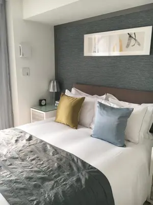 a bedroom with a large white bed with pillows at Oakwood Apartments Minami Azabu Tokyo in Tokyo