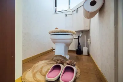 a bathroom with a toilet with two pink shoes on the floor at Murata COPO 305 / Vacation STAY 2893 in Tokyo