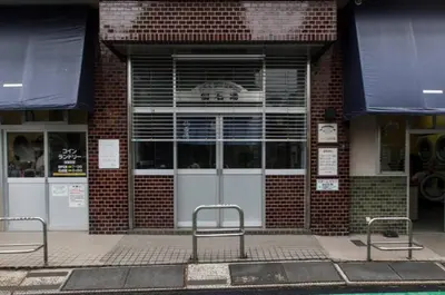 two empty benches in front of a brick building at Dwell Urban 7A in Tokyo