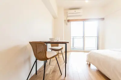 a bedroom with a table and chairs and a bed at Dwell Urban 7B in Tokyo