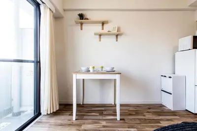 a small white table in a room with a refrigerator at Dwell Urban 6D in Tokyo