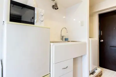 a small kitchen with a sink and a microwave at Dwell Urban 6D in Tokyo