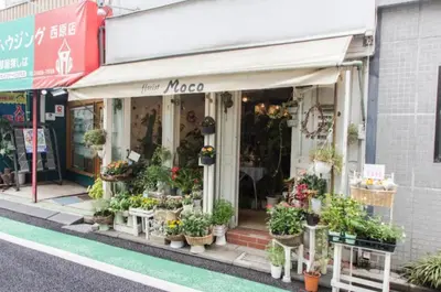 a flower shop with potted plants in front of it at Dwell Urban 6D in Tokyo