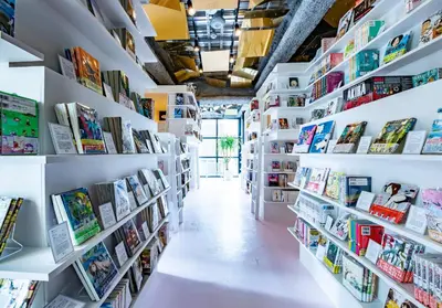 a bookstore with white shelves filled with books at MANGA ART HOTEL, TOKYO in Tokyo