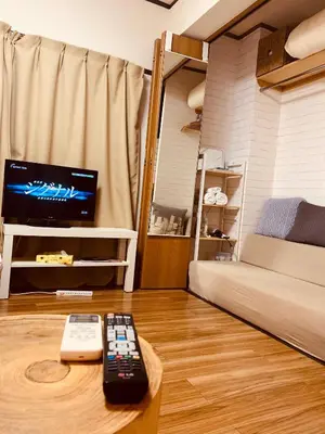 a living room with two remote controls on a table at COCO Nakameguro301 in Tokyo
